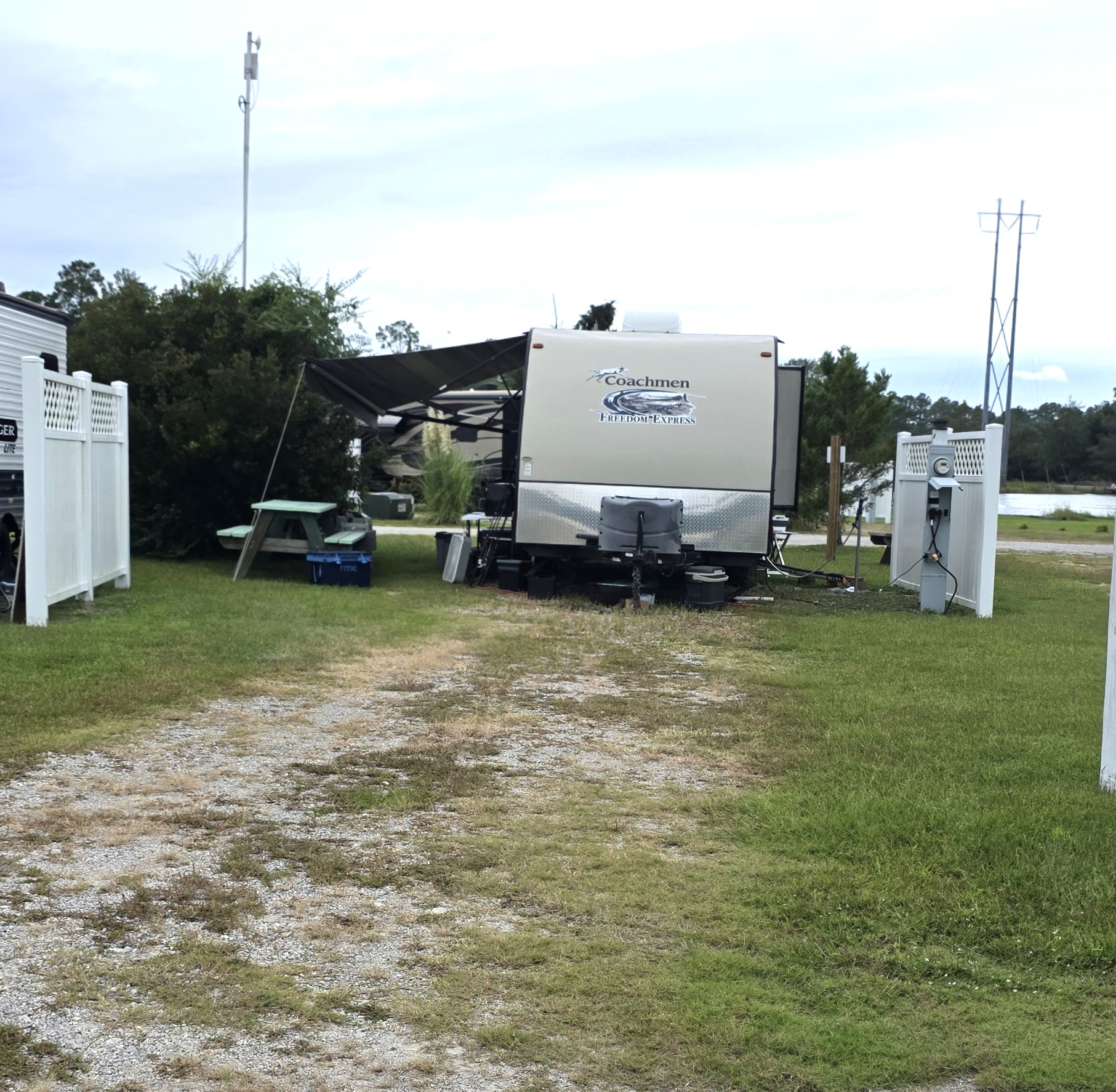 RV site 13 occupied by a travel trailer with lawn, picnic table and utility connections