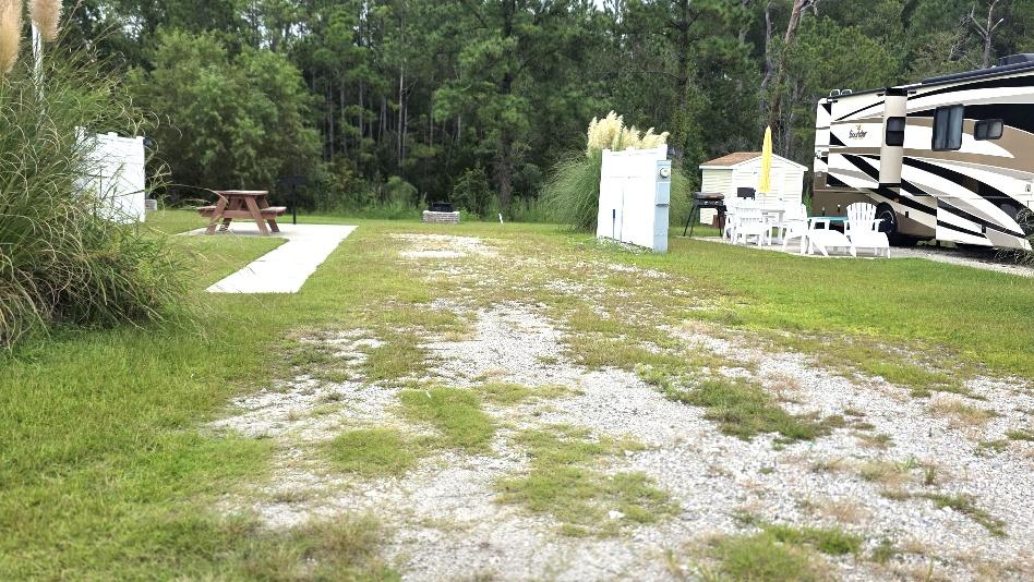 Back-in RV site RV19-166 with a concrete walkway and picnic table