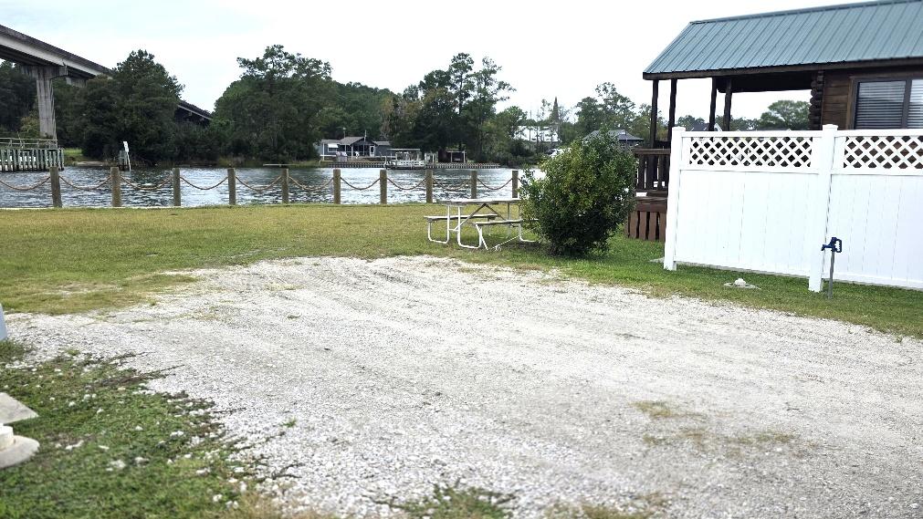 Waterfront RV site RV6-150 with a broad gravel pad beside the water