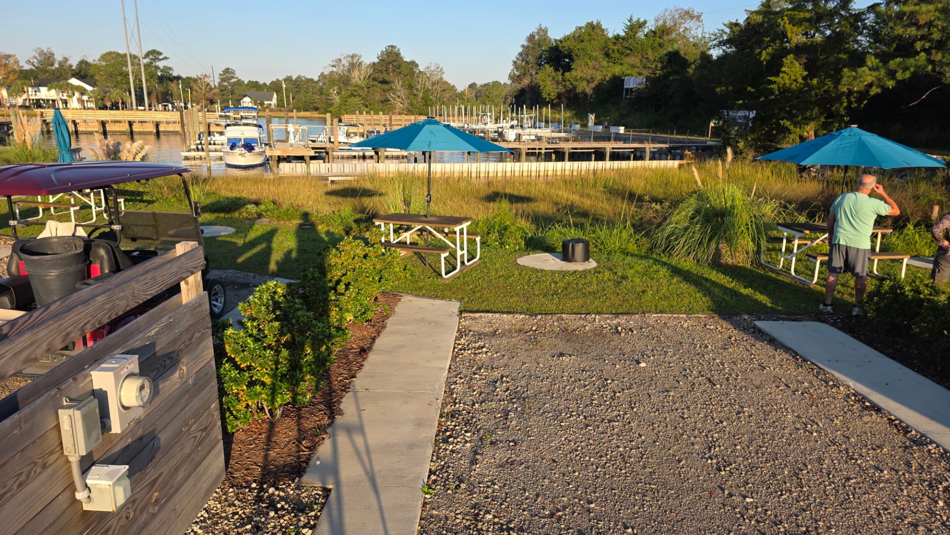 Gravel RV pad at Core Creek site CCR7-110 with picnic tables and the marina beyond